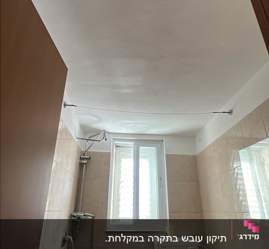 חדר אמבטיה ושירותים עם קיר ותקרה צבועים בלבן